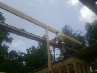 Carpenter setting a ridge beam over a new addition frame — Ice Dam Removal by Roofing Brothers in Harwinton