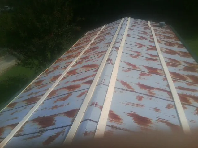 Rusted metal roof panels with new wood purlins before replacement — Storm Damage Roof Repair in Harwinton by Roofing Brothers