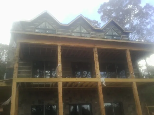 Dormers and porch framing on a large log home under construction — Roof Coating work by our crew in Harwinton