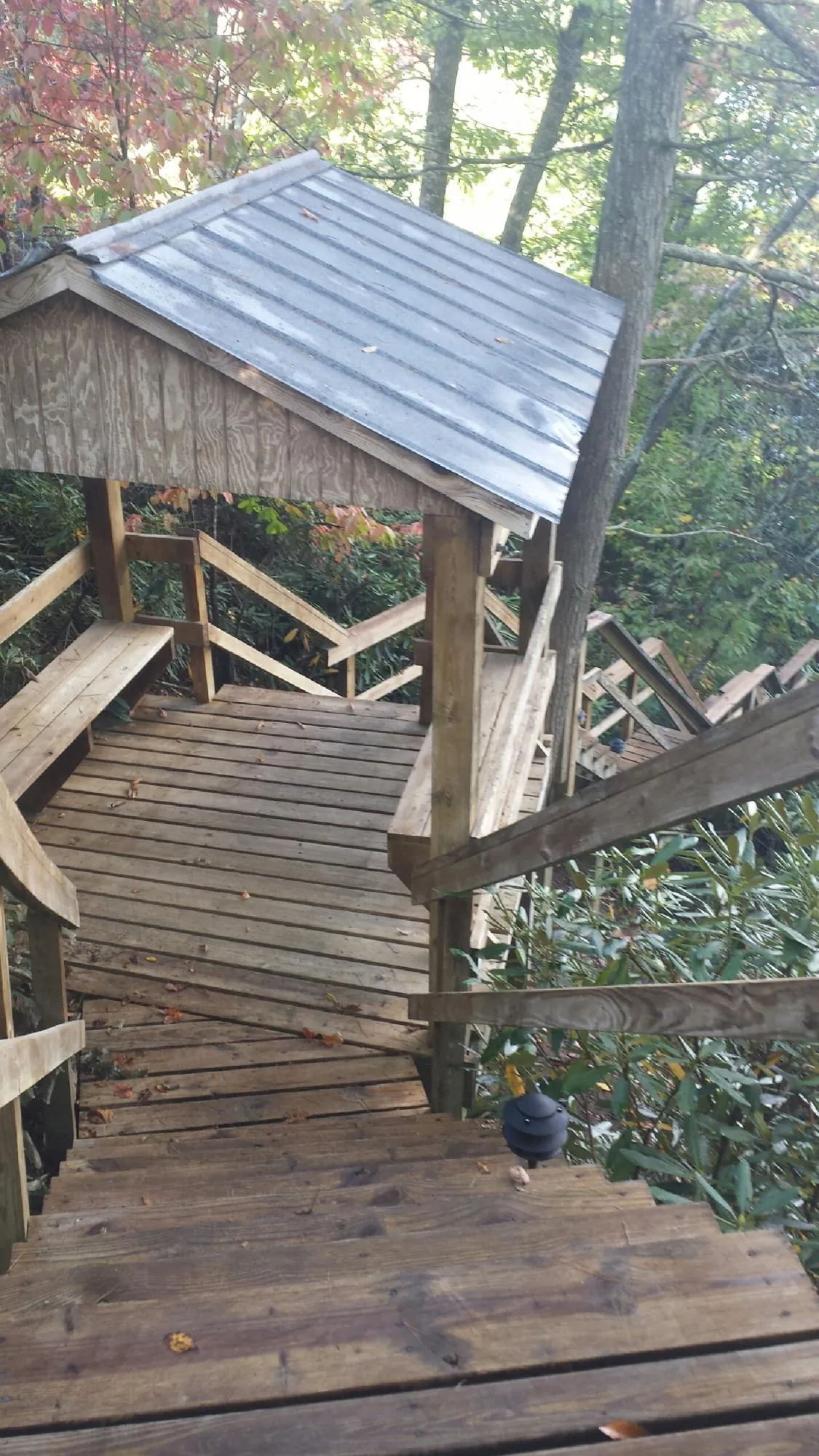 Metal roofed shelter over wooden steps on a wooded walkway — Skylight Repair & Installation work by our crew in Harwinton