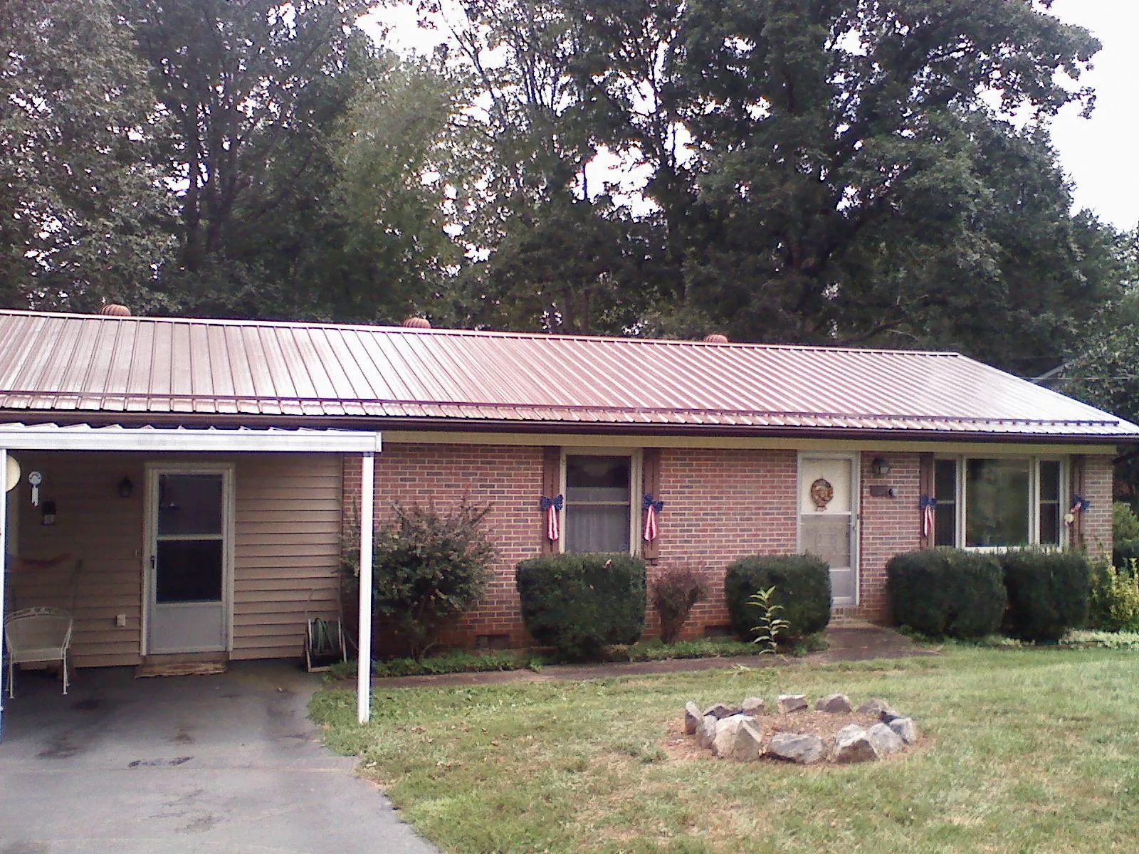 Bronze metal roof and carport on a brick ranch home — Roof Repair work by our crew in Harwinton